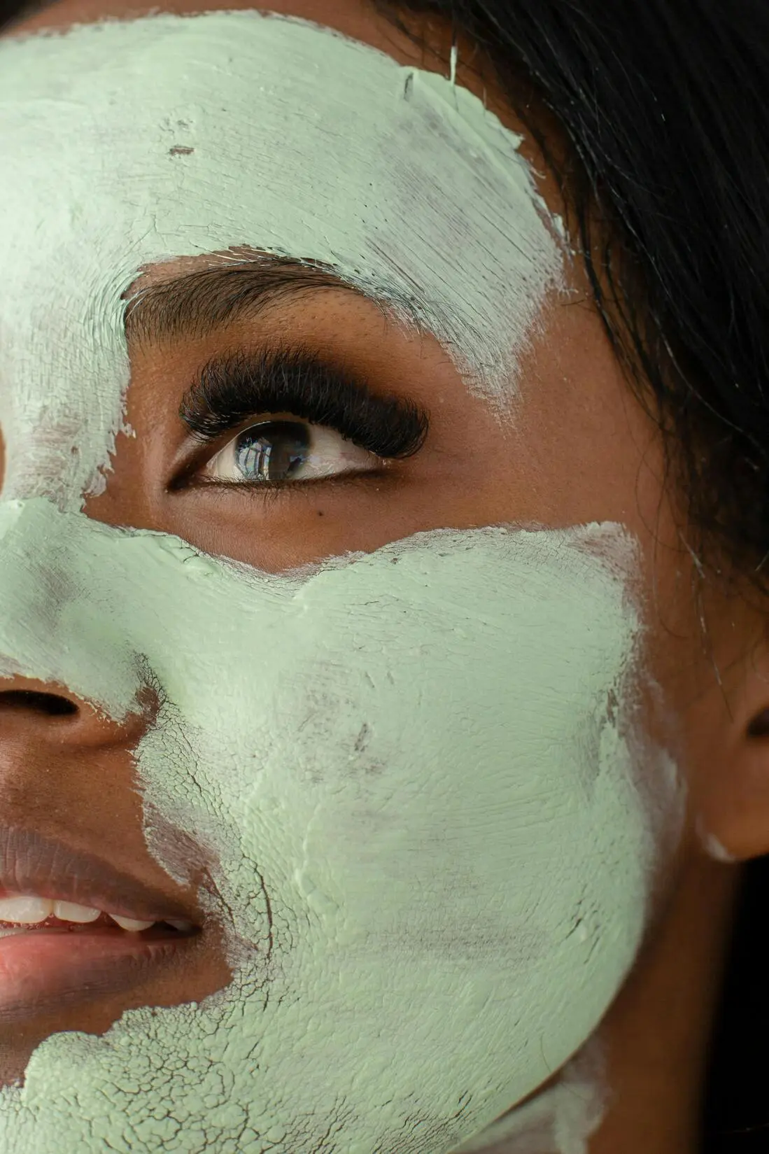 Femme appliquant une crème anti-âge au matcha sur le visage